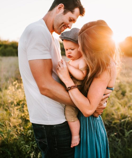 family photo on green grass during golden hour